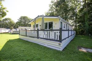 een klein geel en wit huis met een veranda bij Woodlands 55 Cresswell in Ellington