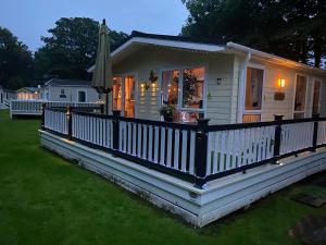 una piccola casa bianca con portico e ombrellone di Woodlands 55 Cresswell a Ellington