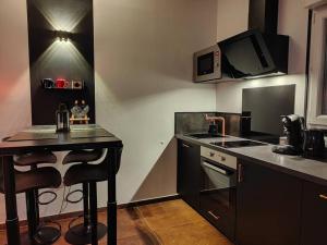 Il comprend une cuisine équipée d'une cuisinière et d'un comptoir. dans l'établissement Le Loft Lens : Jacuzzi - sauna - hammam, à Lens