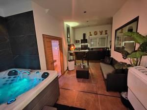 ein Wohnzimmer mit einer Badewanne in der Mitte eines Zimmers in der Unterkunft Le Loft Lens : Jacuzzi - sauna - hammam in Lens