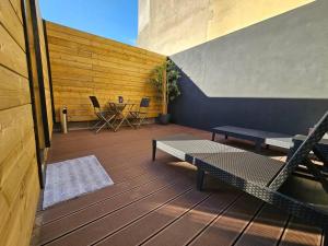 eine Terrasse mit einer Hängematte sowie einem Tisch und Stühlen in der Unterkunft Le Loft Lens : Jacuzzi - sauna - hammam in Lens