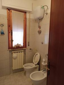 a small bathroom with a toilet and a sink at Casa in collina, vista mare. in Nibbiaia