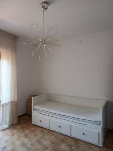 a white bed in a room with a ceiling fan at Casa in collina, vista mare. in Nibbiaia