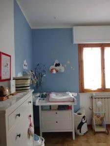 a childs room with a blue wall with a desk at Casa in collina, vista mare. in Nibbiaia