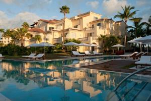 a resort with a swimming pool with chairs and umbrellas at Grace Bay Club in Grace Bay