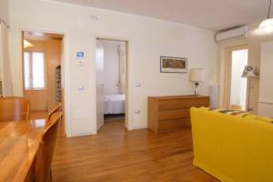 a living room with a table and a yellow couch at Appartamento da Paola in Pescara +1 photo