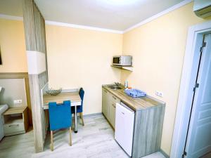 een kleine keuken met een tafel en een magnetron bij Sea View Apartment free parking in Primorsko
