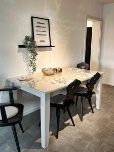 un tavolo bianco con sedie nere intorno di NUMMER EiNS a Neuötting