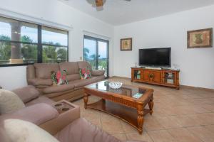 a living room with two couches and a television at Pineapple Villa 531 condo in Roatan