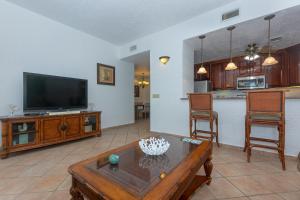 a living room with a television and a coffee table at Pineapple Villa 531 condo in Roatan