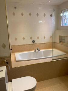 een badkamer met een bad, een toilet en een wastafel bij Aika Homestay in Shah Alam