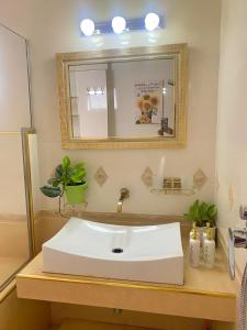 y baño con lavabo blanco y espejo. en Aika Homestay en Shah Alam