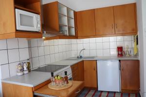a small kitchen with wooden cabinets and white appliances at City Apartment Ierapetra in Ierápetra