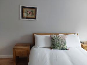 a bedroom with a bed with white sheets and a table at Portobello Charming Seaside 3-BR Holiday Apartment in Edinburgh