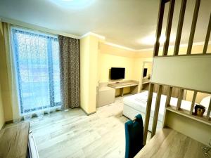 een kamer met een slaapkamer met een bed en een televisie bij Sea View Apartment free parking in Primorsko