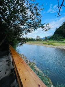 a wooden fence next to a river at Cabana din Luncă in Bistra
