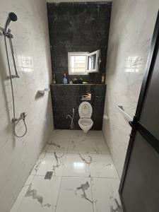 a bathroom with a toilet and a black wall at Maison Blanche in Nouakchott