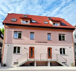 a large pink building with a red roof at Ferienwohnungen am Wasserfall in Bad Urach