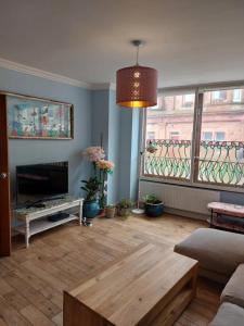 a living room with a fireplace and a large window at Portobello Charming Seaside 3-BR Holiday Apartment in Edinburgh