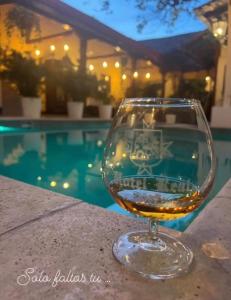 una copa de vino sentada en una mesa junto a una piscina en Hotel Real Leon en León
