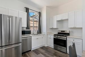 uma cozinha com armários brancos e um frigorífico de aço inoxidável em 4bed 3bath home near Universal studio em Los Angeles