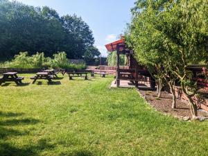 a group of picnic tables in a park at Nad Drawskim DOMKI LETNISKOWE in Czaplinek