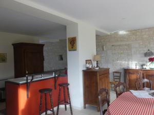 cocina y comedor con mesa y taburetes en Les Chouettes Blanches, en Benet