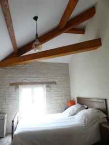 1 dormitorio con cama blanca y ventana en Les Chouettes Blanches, en Benet