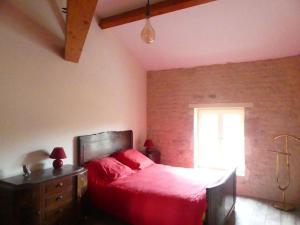 1 dormitorio con cama roja y ventana en Les Chouettes Blanches, en Benet