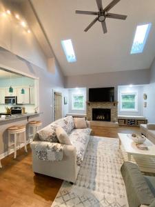 a living room with a white couch and a kitchen at Spacious Home near Gulf Shores & Orange Beach in Foley