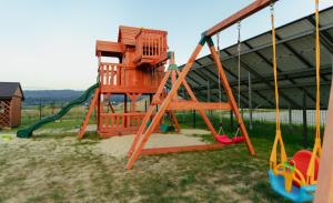 un parque infantil con columpios y estructura de juegos en Winnica Strzegocice, 