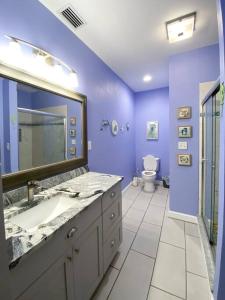 a purple bathroom with a sink and a toilet at Spacious Home near Gulf Shores & Orange Beach in Foley