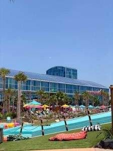 a resort with a pool with people and umbrellas at Spacious Home near Gulf Shores & Orange Beach in Foley