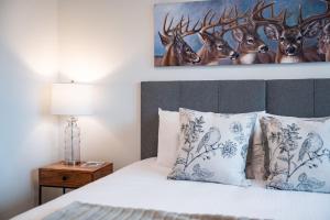a bedroom with a bed with a painting on the wall at Revylation by Revelstoke Vacations in Revelstoke