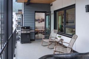 a patio with chairs and a stove on a balcony at Revylation by Revelstoke Vacations in Revelstoke