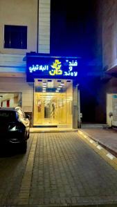 un negozio di fronte con un cartello blu su un edificio di فندق دان البلاتيني a Medina