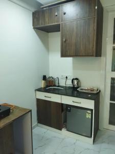 a small kitchen with wooden cabinets and a sink at Seapoint(Seascape) in Dapoli