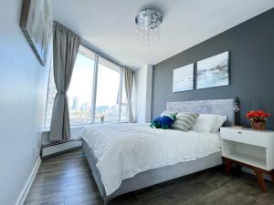 um quarto com uma cama e uma grande janela em Downtown 4bd 2ba View Skytrain 2 Free Parking em Vancouver