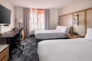 皇后區的住宿－紐約拉瓜迪亞機場/芙拉世迎費爾菲爾德萬豪酒店，酒店客房配有两张床和一张书桌