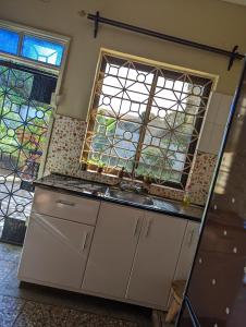 eine Küche mit einem Waschbecken und einem Fenster in der Unterkunft The Lion King Homestay in Moshi