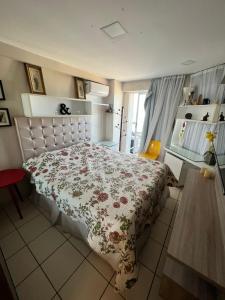 um quarto com uma cama com colcha floral em Apartamento Iracema Fortaleza em Fortaleza