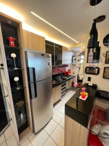 a large kitchen with a stainless steel refrigerator at Apartamento Iracema Fortaleza in Fortaleza
