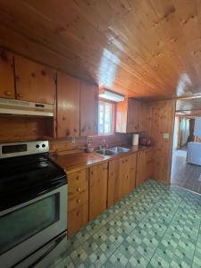 a kitchen with wooden cabinets and a stove top oven at Cottage in Crystal Beach in Fort Erie