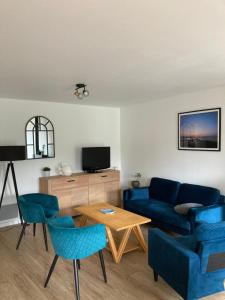 a living room with a blue couch and a table at Rive droite bord de plage in Réville