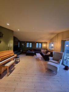 史特林的住宿－Charming house by a small lake，客厅配有钢琴和沙发