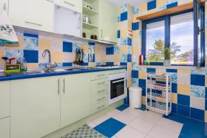 cocina con azulejos azules y blancos en la pared en Apartamentos Orada - Marina De Albufeira, en Albufeira