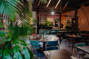 ein Restaurant mit Tischen, Stühlen und Pflanzen in der Unterkunft The Social Hub Amsterdam City in Amsterdam