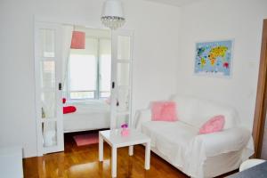 uma sala de estar com um sofá branco e uma cama em Mini Cooper Kajzerica em Zagreb