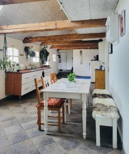 a kitchen and dining room with a white table and chairs at Kreativgård Hoge in Højer