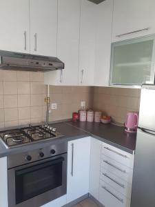 uma cozinha com armários brancos e um forno com placa de fogão em Mini Cooper Kajzerica em Zagreb
